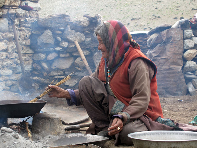 Femme grillant de l’orge. Chez les nomades aussi, l’orge est la base de l’alimentation. Autrefois troqué contre du sel, il est aujourd’hui acheté aux paysans du Ladakh central.